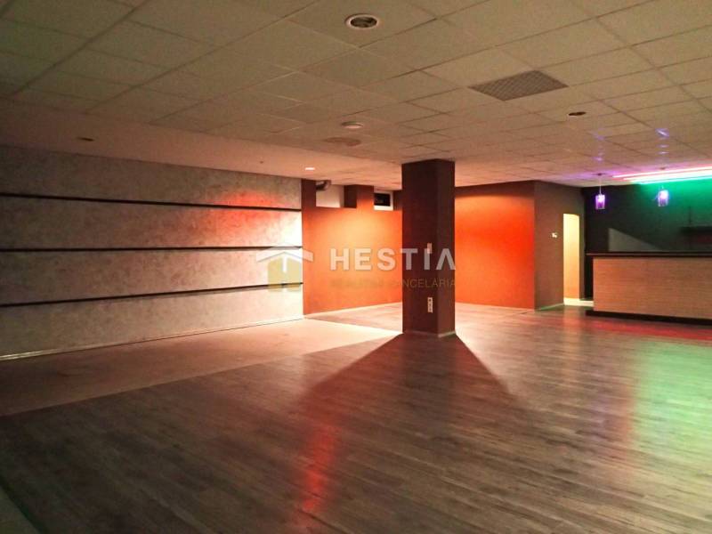 Veľký komerčný priestor 292 m2 priamo v centre mesta - Veľká miestnosť s drevenou podlahou a farebným osvetlením, vhodná na obchodné priestory.