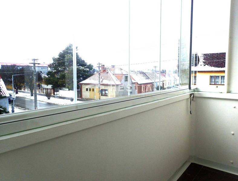 ZNÍŽENÁ CENA Veľký 2-izbový investičný byt Senica - 73,54 m² - Presklený balkón s výhľadom na zimnú ulicu v Senici, 2-izbový byt.