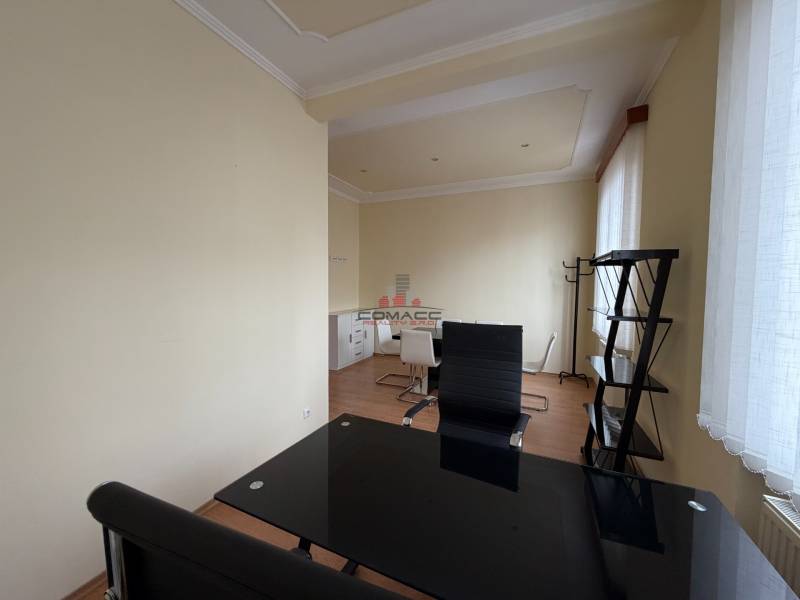 Prenájom kancelárie 33 m2 v centre Piešťan - Interiér kancelárie s nábytkom a podlahou s dreveným dekorom.