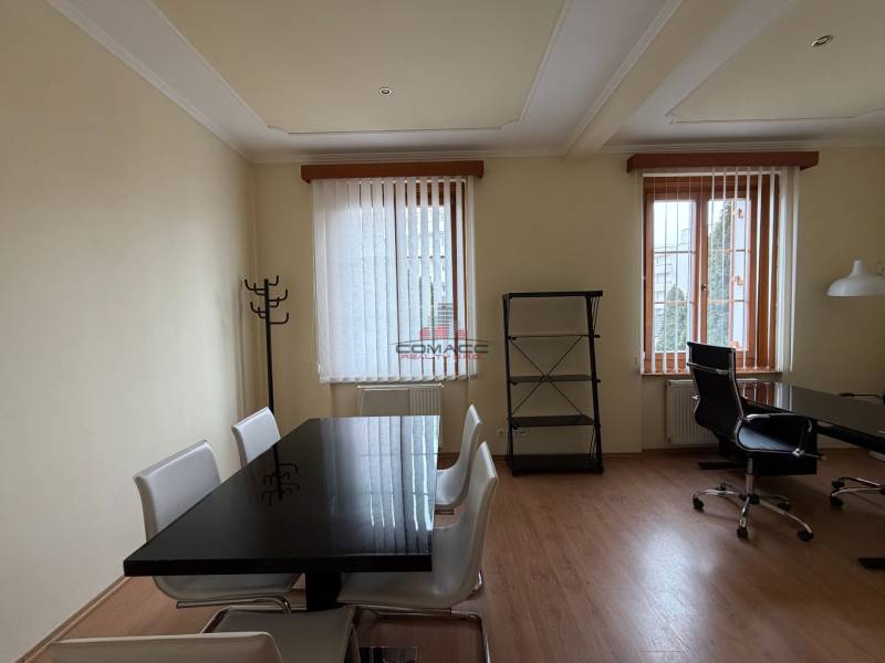 Prenájom kancelárie 33 m2 v centre Piešťan - Kancelárie s podlahou s dreveným dekorom, bielymi stenami a čiernym stolom.