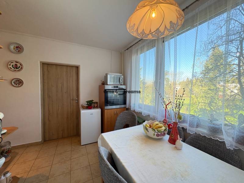 Na predaj: 4 izb.byt + BALKON + ŠATNIK + ŠPAJZA - Kuchyňa v 3-izbovom byte so stolom a veľkým oknom s výhľadom.