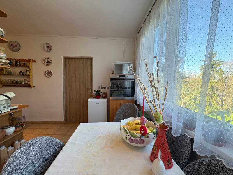 Na predaj: 4 izb.byt + BALKON + ŠATNIK + ŠPAJZA - Jedáleň v 3-izbovom byte so stolom, dekoráciami a výhľadom do zelene.