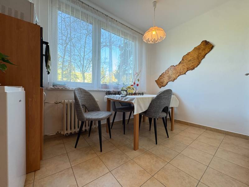 Na predaj: 4 izb.byt + BALKON + ŠATNIK + ŠPAJZA - Jedálenský kút v 3-izbovom byte s troma stoličkami a dekorom na stene.