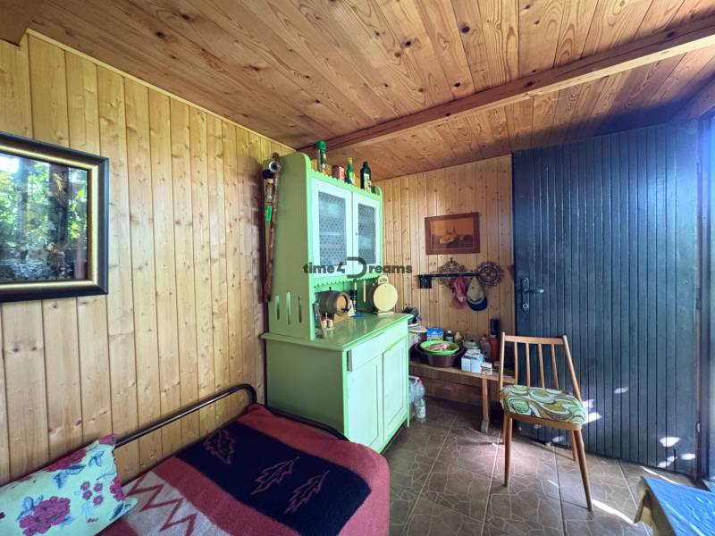 Na predaj: Ovocná záhrada v Leviciach - Drevený interiér záhrady s rustikálnym nábytkom a dekoráciami.