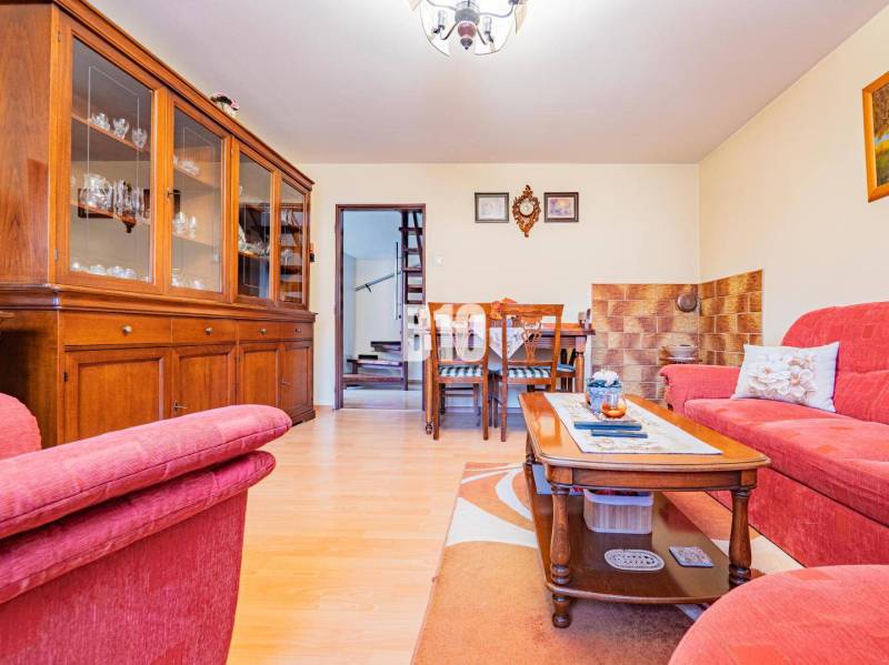 POD HRADOM bývanie alebo podnikanie - Rodinný dom so svetlou obývacou miestnosťou, dreveným nábytkom a sedačkou, podlaha s dreveným dekorom.