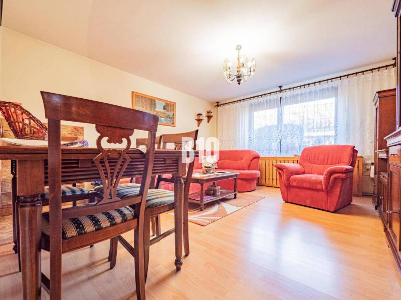 POD HRADOM bývanie alebo podnikanie - Obývacia izba v rodinnom dome s podlahou s dreveným dekorom a červenými sedacími súpravami.