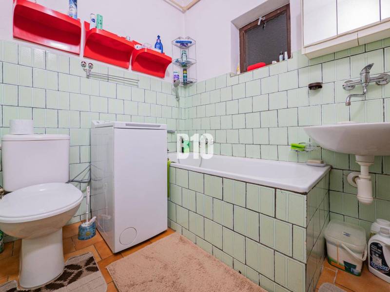 POD HRADOM bývanie alebo podnikanie - Kúpeľňa v rodinnom dome s vaňou, umývadlom a práčkou, s bledozeleným obkladom.