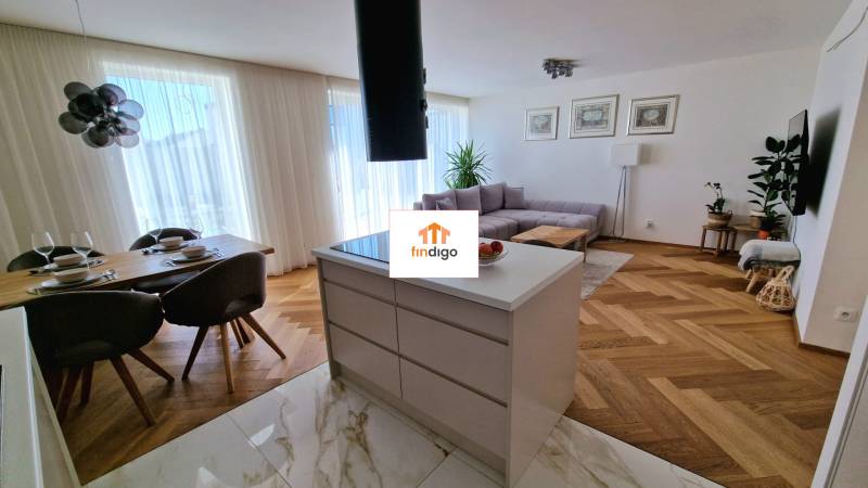 PRENÁJOM - 4 izbový rodinný dom, ktorý je súčasťou dvojdomu   - Otvorený priestor v rodinnom dome s kuchyňou, jedálenským stolom a podlahou s dreveným dekorom.