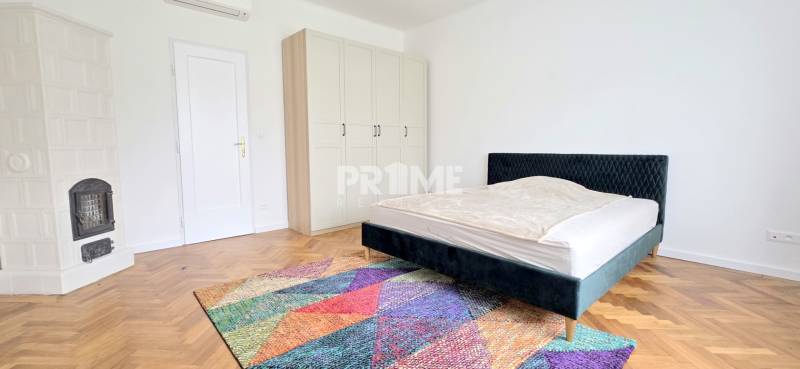 Pekný 3i byt, REKONŠTRUKCIA, KLÍMA, NIVY, Trenčianska ulica - Spálňa v 3-izbovom byte, ulica Trenčianska, obsahuje krb, farebný koberec a modernú posteľ.