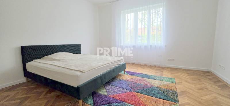 Pekný 3i byt, REKONŠTRUKCIA, KLÍMA, NIVY, Trenčianska ulica - Spálňa Trenčianska, priestranná izba, posteľ a farebný koberec. Trojizbový byt svetlý.