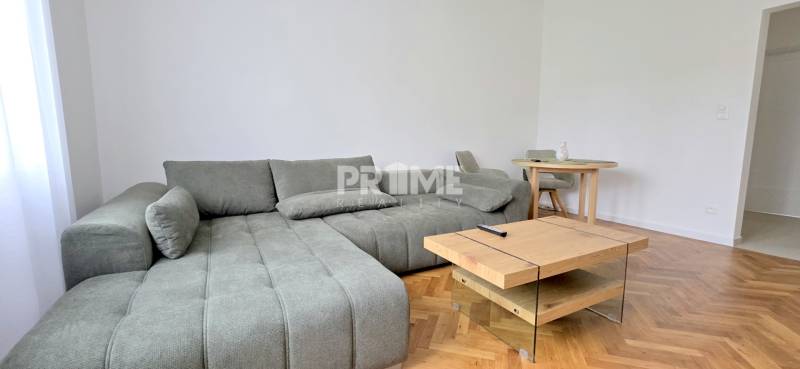 Pekný 3i byt, REKONŠTRUKCIA, KLÍMA, NIVY, Trenčianska ulica - Svetlý obývací priestor na ulici Trenčianska, vybavený pohodlnou pohovkou a dreveným stolíkom pre 3-izbový byt.