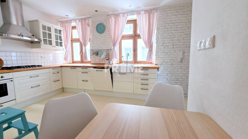 JEDINEČNÝ 2i byt, REKONŠT., 2 X .SAMOST.IZBA, Hviezdoslavovo nám.  - Kuchyňa v 2-izbovom byte s bielymi skrinkami a tehlovou stenou.