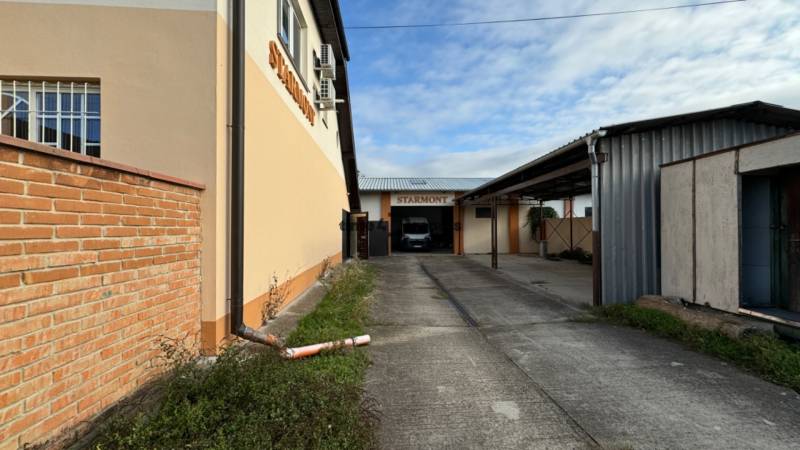 NA PREDAJ rodinný dom/polyfunkcia Komjatice  - Priemyselná stavba s logom STARMONT, prístupová cesta, **a priemyselná zóna**.