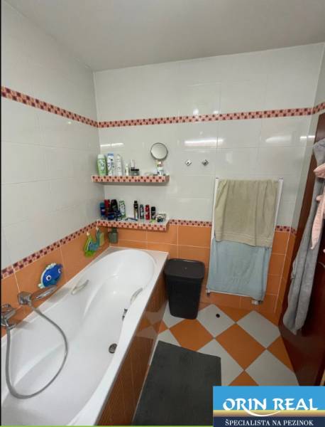 PREDAJ PRIESTRANNÉHO 3 IZB. BYTU NA MUŠKÁTE S GARÁŽOVÝM STÁTIM - Kúpeľňa v 3-izbovom byte s vaňou a oranžovo-bielym obkladom.