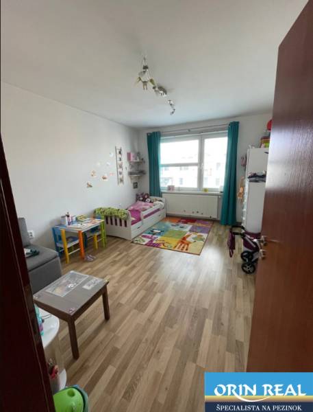 PREDAJ PRIESTRANNÉHO 3 IZB. BYTU NA MUŠKÁTE S GARÁŽOVÝM STÁTIM - Detská izba v 3-izbovom byte s hračkami a podlahou s dreveným dekorom.