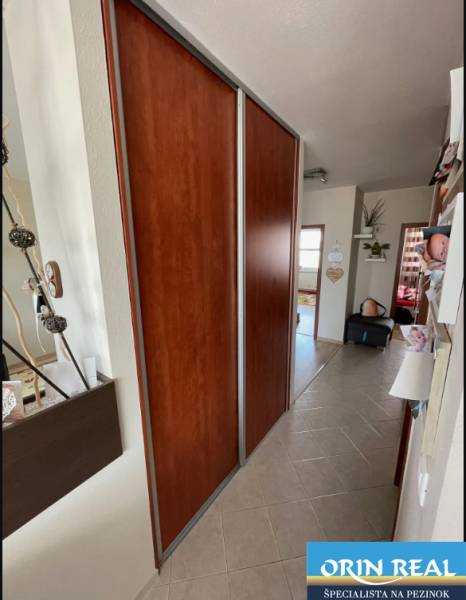 PREDAJ PRIESTRANNÉHO 3 IZB. BYTU NA MUŠKÁTE S GARÁŽOVÝM STÁTIM - Chodba 3-izbového bytu s dlažbou a vstavanou skriňou s posuvnými dverami.