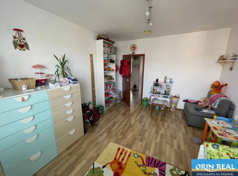 PREDAJ PRIESTRANNÉHO 3 IZB. BYTU NA MUŠKÁTE S GARÁŽOVÝM STÁTIM - Detská izba v 3-izbovom byte s podlahou s dreveným dekorom a hračkami.