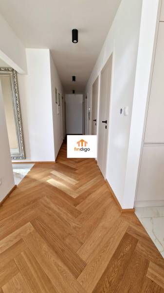 PRENÁJOM - 4 izbový rodinný dom, ktorý je súčasťou dvojdomu   - Chodba s podlahou s dreveným dekorom v rodinnom dome, biele steny, zrkadlo a dvere.