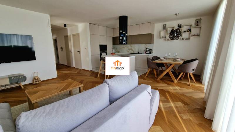 PRENÁJOM - 4 izbový rodinný dom, ktorý je súčasťou dvojdomu   - Obývacia izba v rodinnom dome s podlahou s dreveným dekorom a kuchynským kútom.