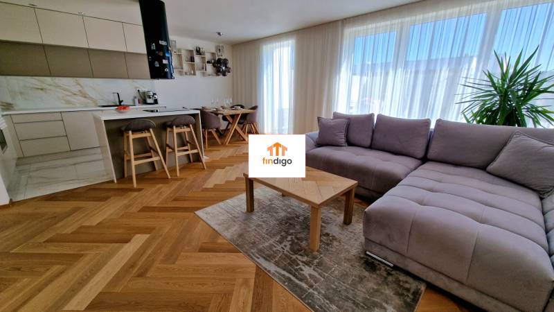 PRENÁJOM - 4 izbový rodinný dom, ktorý je súčasťou dvojdomu   - Obývacia izba v rodinnom dome s kuchynským kútom a podlahou s dreveným dekorom.