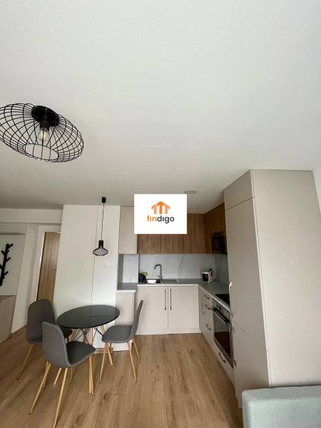 PRENÁJOM - 3-izbový krásny kompletne zrekonštruovaný byt - Mostná - Kuchynský kút v 3-izbovom byte s jedálenským stolom a podlahou s dreveným dekorom.