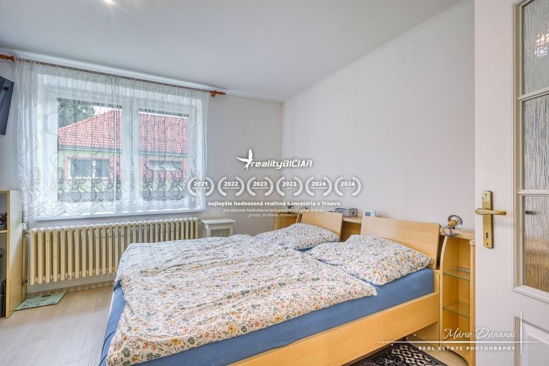 NOVÁ CENA - 5-izbový rodinný dom, dve garáže a krásny pozemok Špačince - Spálňa v rodinnom dome s veľkým oknom a dvojposteľou.
