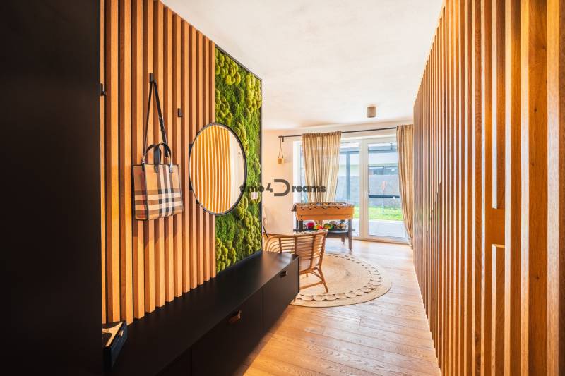 NA PREDAJ Krásny domček v Ivánke pri Nitre - Interiér rodinného domu s dreveným dekorom, živou stenou a priehľadom na záhradu.