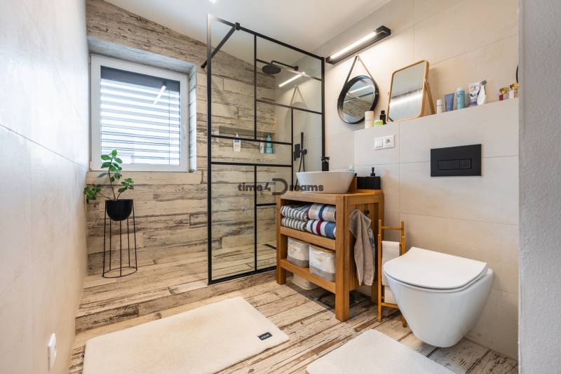 NA PREDAJ Krásny domček v Ivánke pri Nitre - Kúpeľňa v rodinnom dome s podlahou s dreveným dekorom a sprchovým kútom.