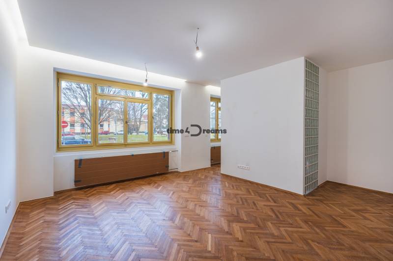 NA PREDAJ štýlový byt v centre Nitry  - Priestranná izba s podlahou s dreveným dekorom v 3-izbovom byte.