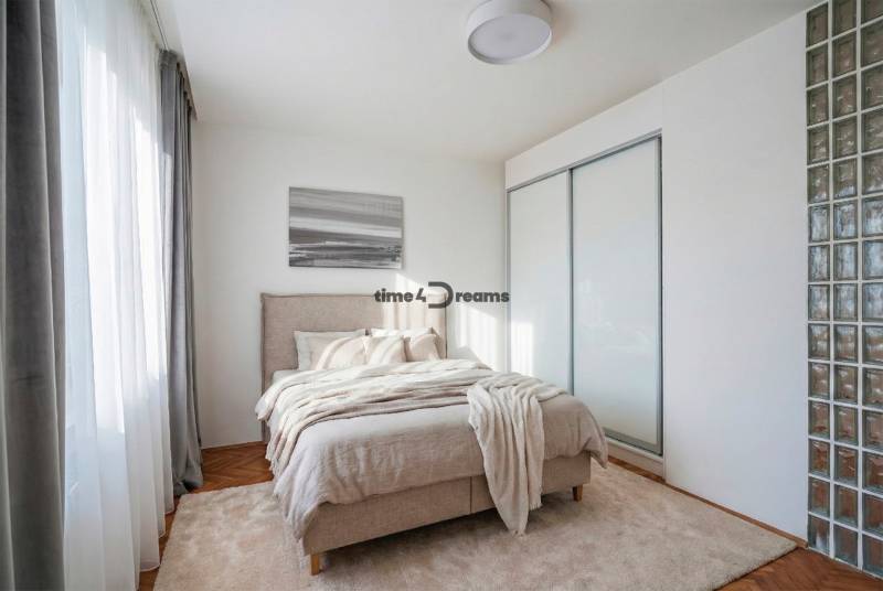 NA PREDAJ štýlový byt v centre Nitry  - Spálňa v 3-izbovom byte s pohodlnou posteľou, presklenými dverami a podlahou s dreveným dekorom.