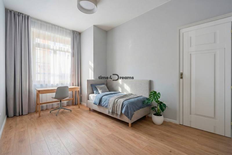 NA PREDAJ štýlový byt v centre Nitry  - Svetlá spálňa s podlahou s dreveným dekorom, posteľou a písacím stolom v 3-izbovom byte.