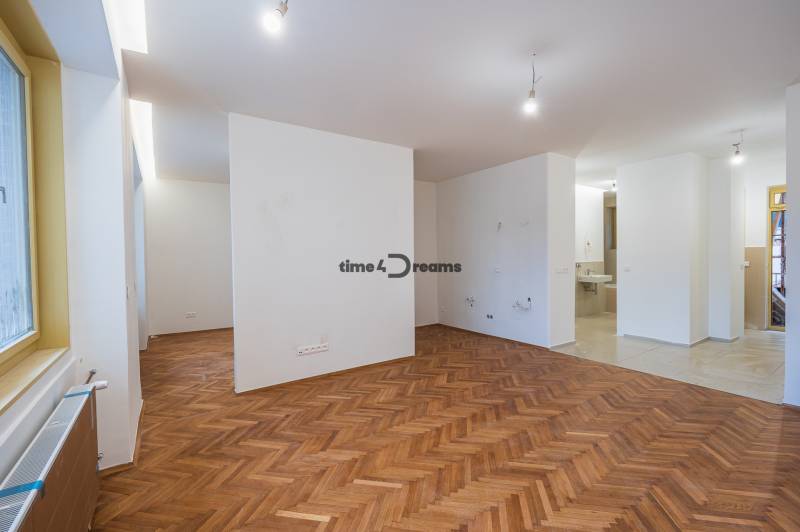 NA PREDAJ štýlový byt v centre Nitry  - Interiér s podlahou s dreveným dekorom a prázdnymi stenami v 3-izbovom byte.