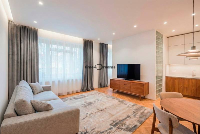 NA PREDAJ štýlový byt v centre Nitry  - Obývačka so sedačkou, televízorom a podlahou s dreveným dekorom v 3-izbovom byte.