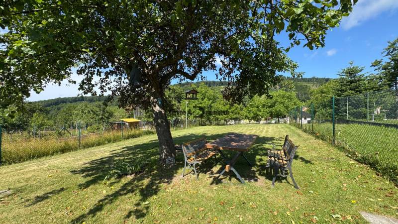 NA PREDAJ krásny pozemok pre váš nový Dom alebo Chalupu - Záhrada v Novej Bani s lavičkou a stolom na pozemkoch pre bývanie.