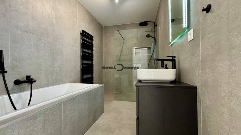 NA PREDAJ 4 izbový rodinný dom Štitáre NITRA - Kúpeľňa s vaňou a sprchou v rodinnom dome s čiernymi doplnkami.