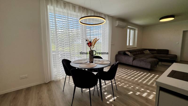 NA PREDAJ 4 izbový rodinný dom Štitáre NITRA - Jedálenský stôl s riadom a dekoráciou, pohovka, podlaha s dreveným dekorom.