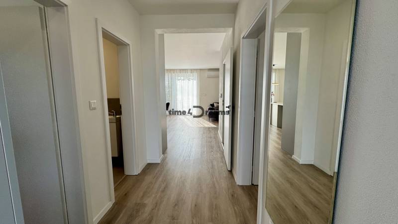 NA PREDAJ 4 izbový rodinný dom Štitáre NITRA - Chodba v rodinnom dome s podlahou s dreveným dekorom a zrkadlom na stene.