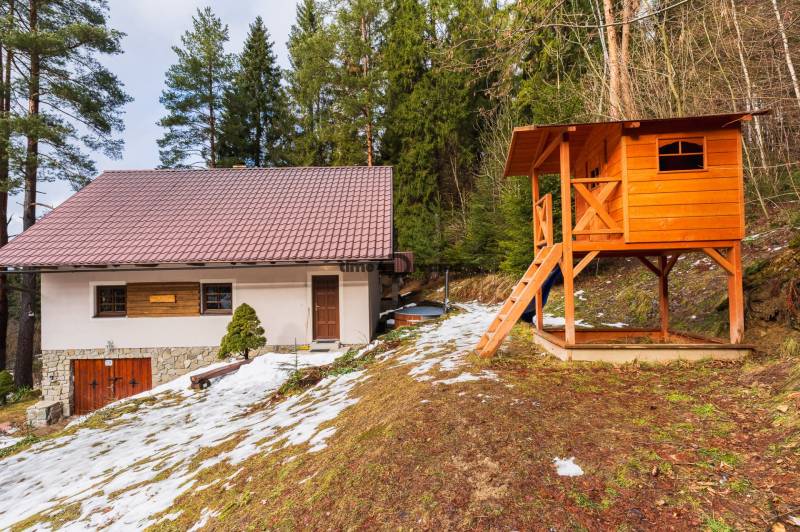 NA PREDAJ Chalúpka na Oravskej Priehrade NÁMESTOVO - Chata na slanickej osade v Námestove so snehom a drevenou detskou šmykľavkou.