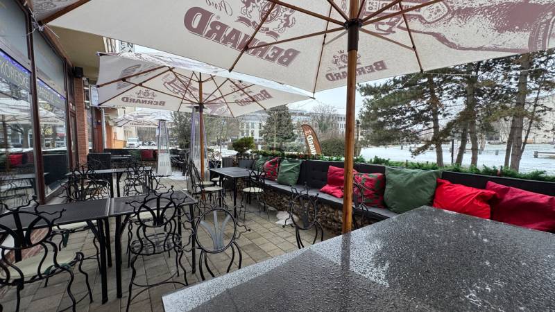 ODSTÚPENIE Gastro prevádzky na Námestí v Nitre - Gastro priestory na Svätoplukovom námestí v Nitre, terasa so stolmi a slnečníkmi.