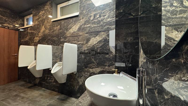 ODSTÚPENIE Gastro prevádzky na Námestí v Nitre - Toaleta s mramorovými stenami a umývadlom v gastro priestoroch.