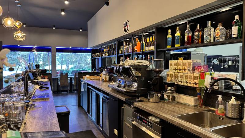 ODSTÚPENIE Gastro prevádzky na Námestí v Nitre - Interiér gastro priestoru s barovým pultom, vybavením a výhľadom vonku.