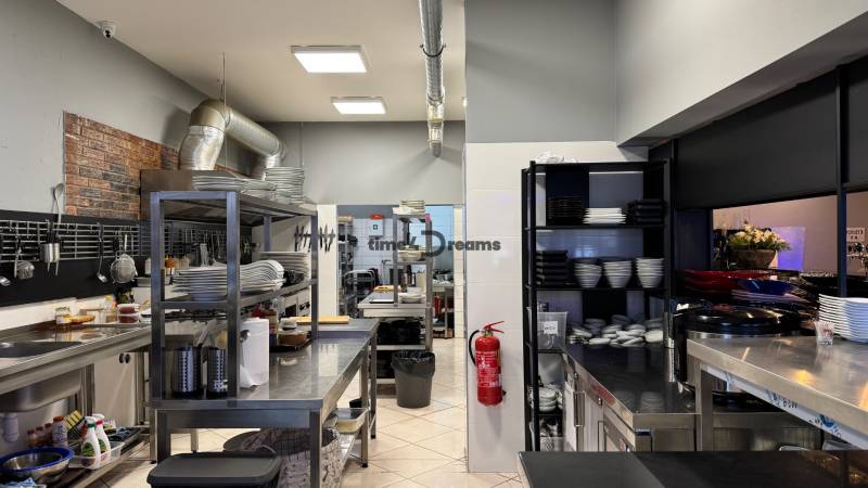 ODSTÚPENIE Gastro prevádzky na Námestí v Nitre - Profesionálna kuchyňa v gastro priestoroch s vybavením a porcelánovými taniermi.