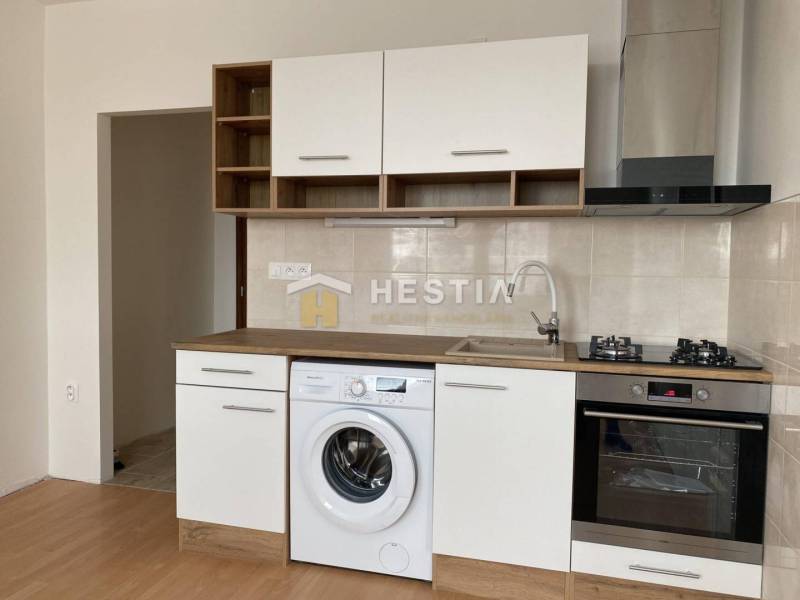 NA PRENÁJOM zrekonštruovaný 1-IZB.BYT, Štefánikova ul., Senica - Kuchyňa v 1-izbovom byte s práčkou a podlahou s dreveným dekorom.