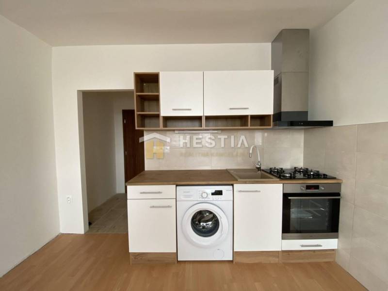 NA PRENÁJOM zrekonštruovaný 1-IZB.BYT, Štefánikova ul., Senica - Kuchyňa v 1-izbovom byte s podlahou s dreveným dekorom a spotrebičmi.