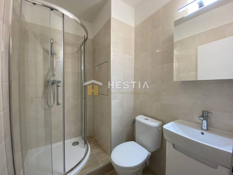 NA PRENÁJOM zrekonštruovaný 1-IZB.BYT, Štefánikova ul., Senica - Kúpeľňa s rohovým sprchovým kútom v 1-izbovom byte, béžové obklady, umývadlo, zrkadlo.