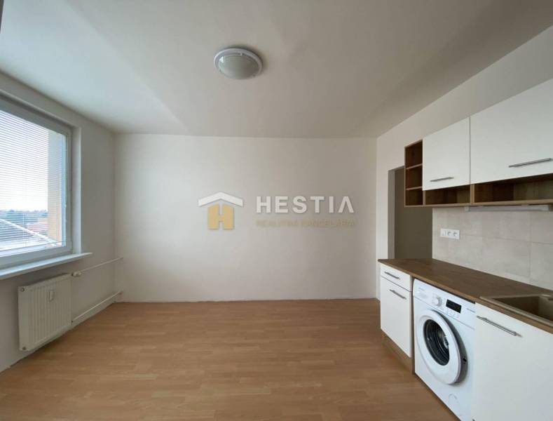 NA PRENÁJOM zrekonštruovaný 1-IZB.BYT, Štefánikova ul., Senica - Kuchynská časť s práčkou a podlahou s dreveným dekorom v 1-izbovom byte.