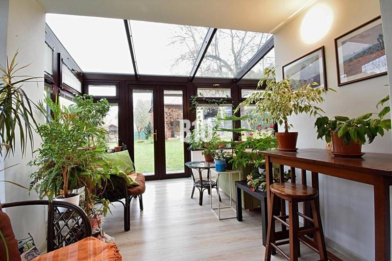 Zaujímavý rodinný dom s veľkým pozemkom, krásnou záhradou a bohatým pr - Svetlá zimná záhrada v rodinnom dome so zeleňou a presklenou strechou.