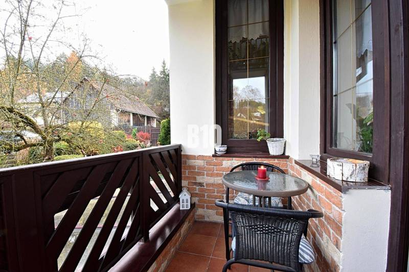 Zaujímavý rodinný dom s veľkým pozemkom, krásnou záhradou a bohatým pr - Balkón rodinného domu v Lietave s tehlovým obkladom a výhľadom na záhradu.