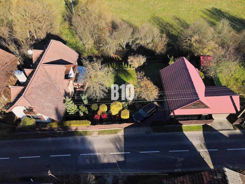 Zaujímavý rodinný dom s veľkým pozemkom, krásnou záhradou a bohatým pr - Letecký pohľad na záhradu a rodinný dom v Lietave pri ceste.