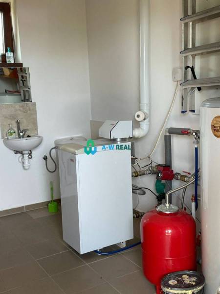 Apartmánový dom na predaj blízko termálneho kúpaliska - Pohľad na technickú miestnosť s umývadlom a kotlom, vhodnú pre obchodné priestory.